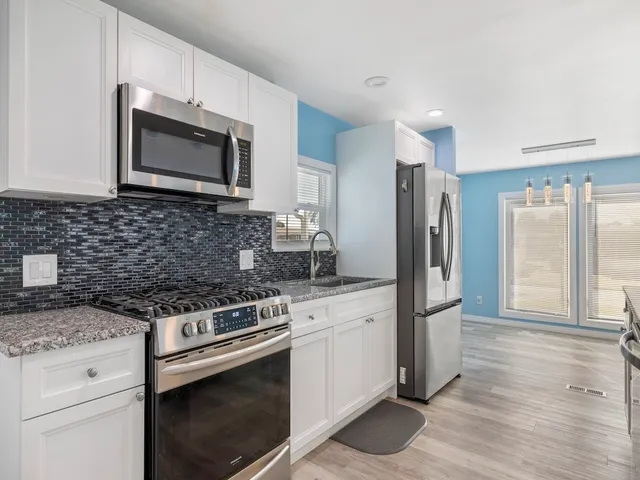 a kitchen with granite countertop a stove and a sink