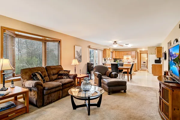 a living room with furniture and a flat screen tv with kitchen view