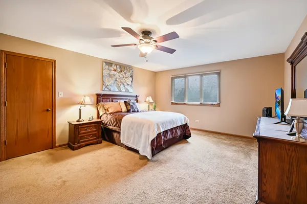 a bedroom with a bed and dresser with mirror
