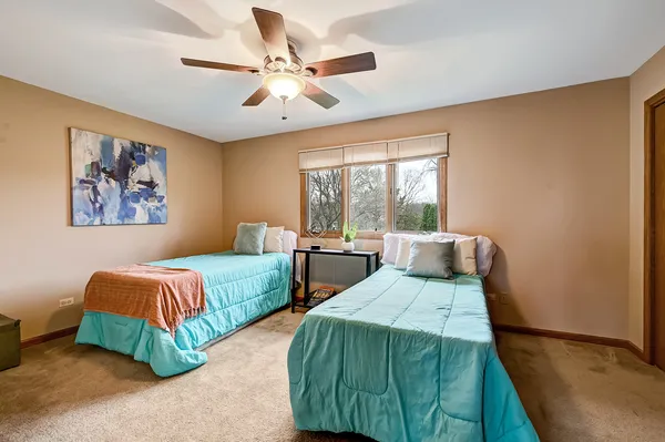 a bedroom with two beds and painting on the wall