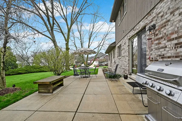 a view of a backyard with table and chairs and a large tree