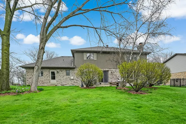 a aerial view of a house next to a big yard and large trees