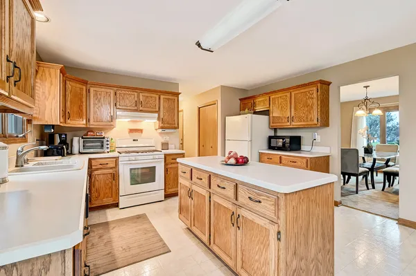 a kitchen that has a lot of white cabinets and stainless steel appliances