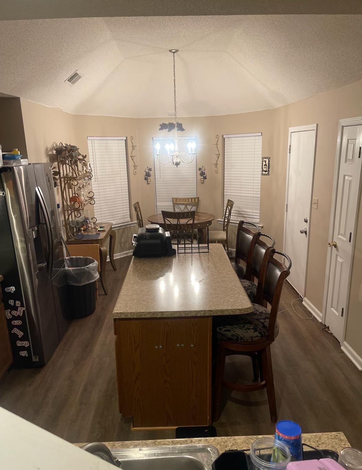 4499 Kings Station Road Millington, TN 38053 - Photo 3 of 4 Dining area featuring dark wood-style floors, visible vents, vaulted ceiling, and a textured ceiling