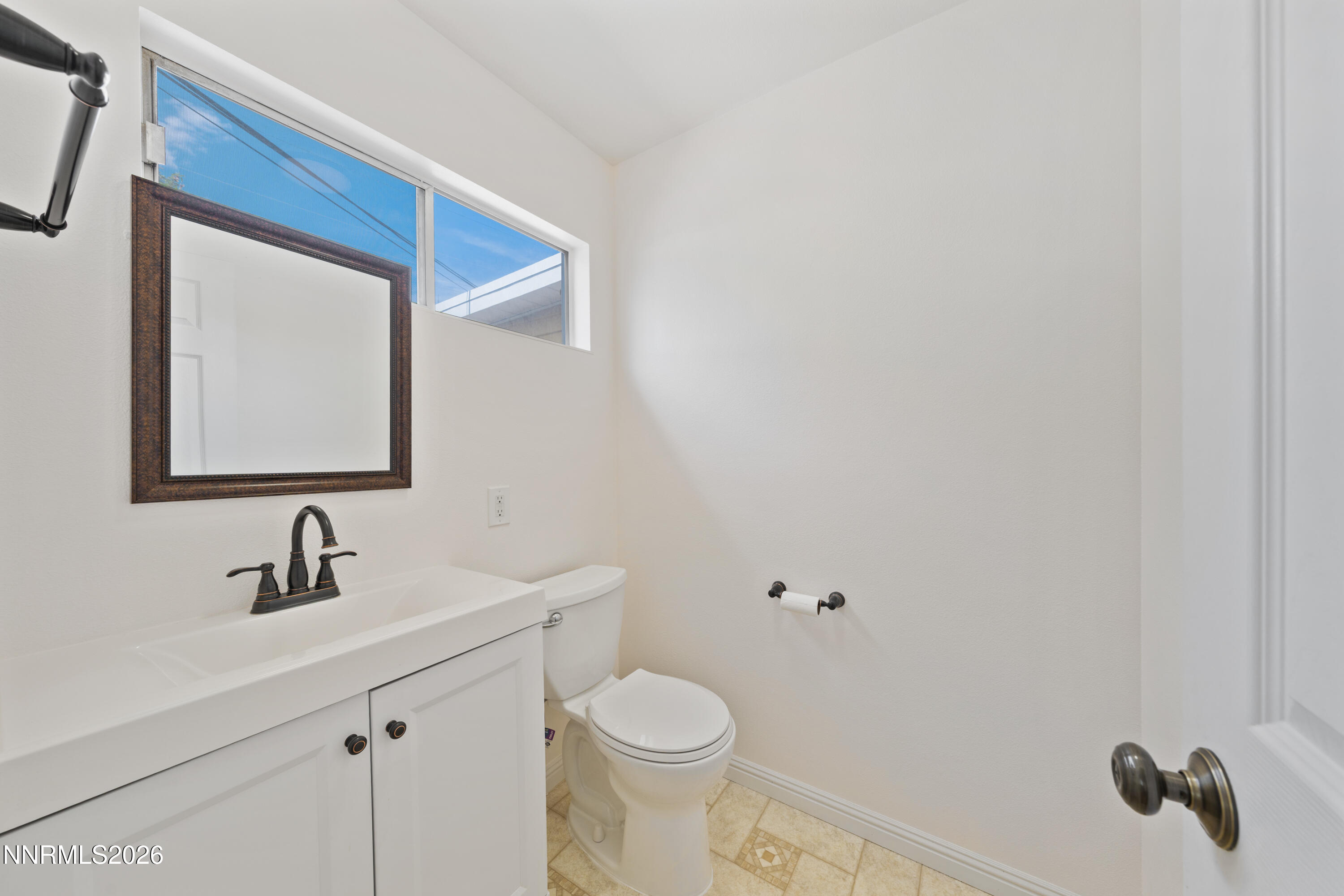 1540 Tyler Way Sparks, NV 89431 - Photo 14 of 30 a bathroom with a toilet sink and mirror