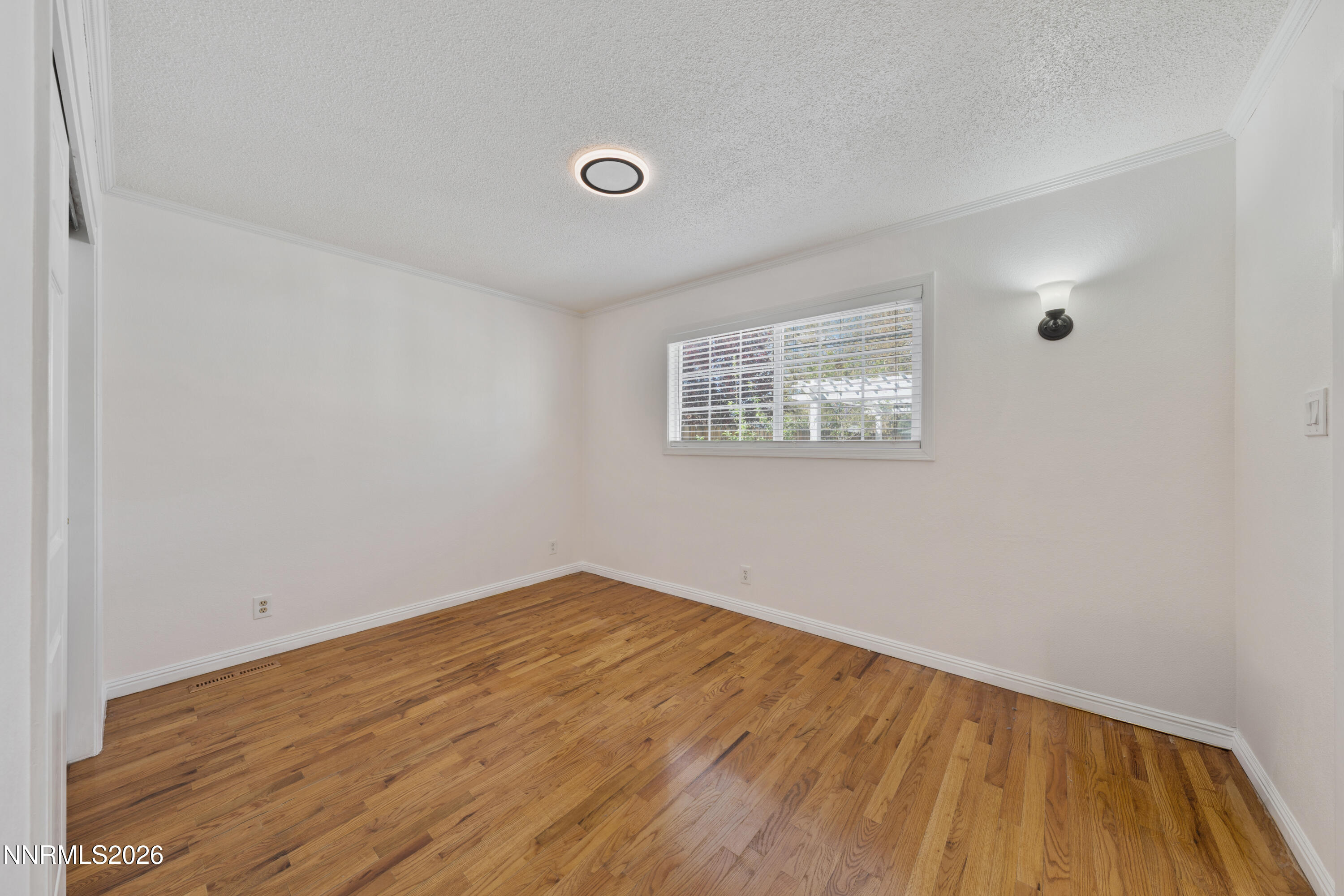 1540 Tyler Way Sparks, NV 89431 - Photo 10 of 30 a view of an empty room with wooden floor and a window