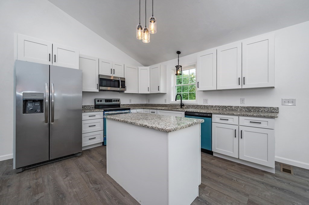 20 May Brook Road Holland, MA 01521 - Photo 9 of 28 a kitchen with granite countertop a refrigerator a sink dishwasher a stove and white cabinets with wooden floor
