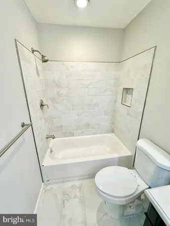 a bathroom with a toilet and a bath tub