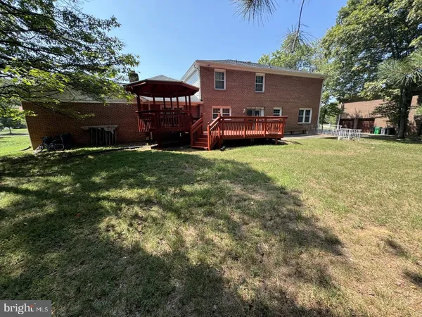 a front view of a house with a garden and trees
