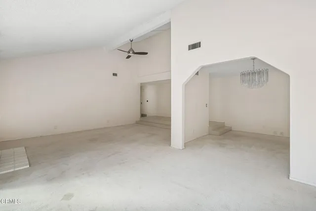 an empty room with a ceiling fan and bathroom view