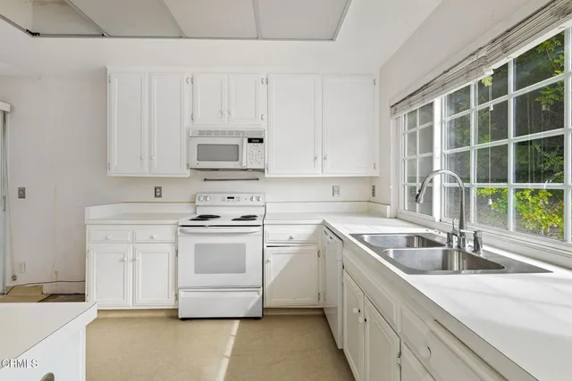 a kitchen with granite countertop white cabinets and a sink
