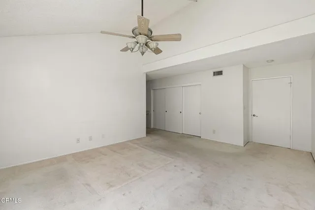 an empty room with a chandelier fan