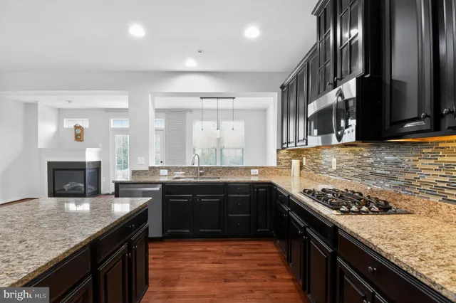 a large kitchen with stainless steel appliances granite countertop a stove sink and cabinets