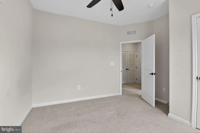 an empty room with a ceiling fan and a window