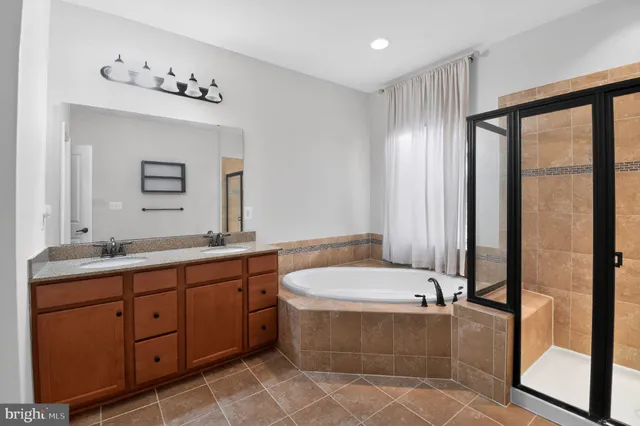 a bathroom with a tub sink and mirror