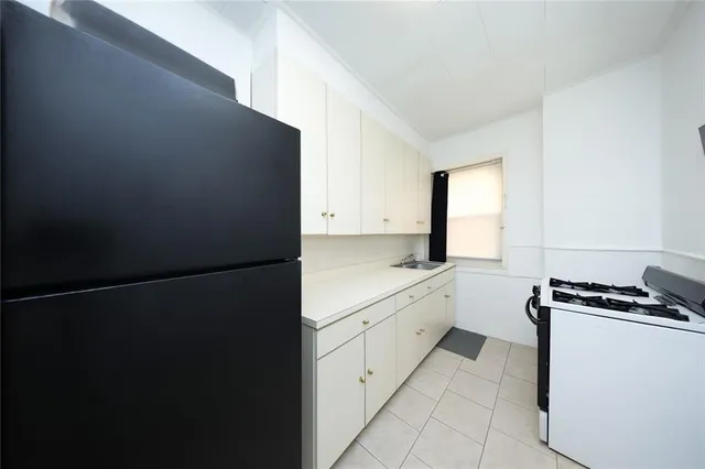 a kitchen with a refrigerator and white cabinets
