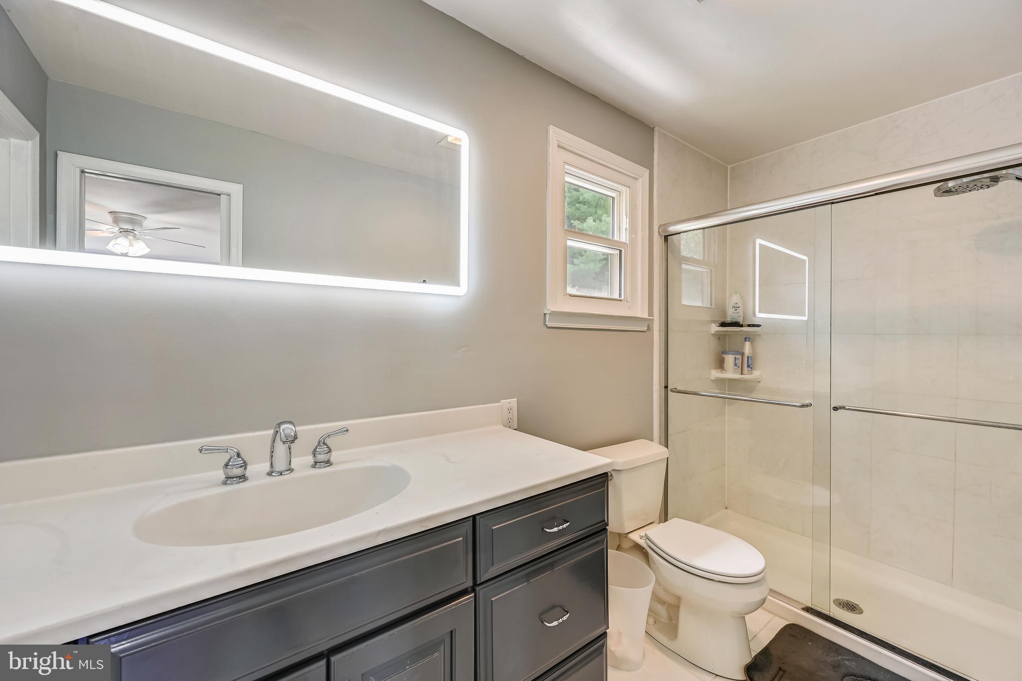 2116 Kings House Road Silver Spring, MD 20905 - Photo 25 of 37 a bathroom with a sink toilet a mirror and shower