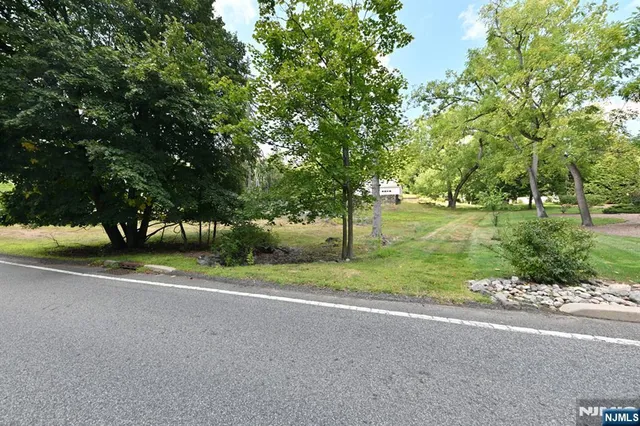 a view of a house with a big yard and palm trees