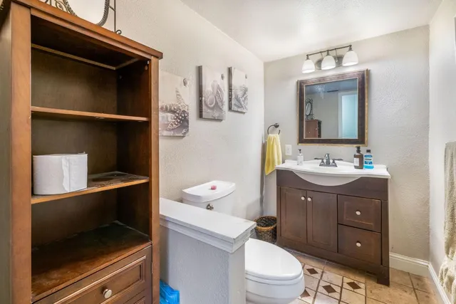 a bathroom with a sink vanity granite and toilet