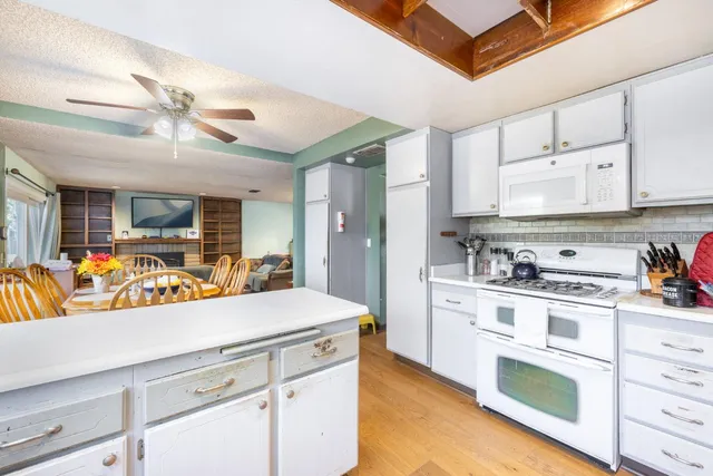 a view of a kitchen with kitchen island a sink stainless steel appliances and cabinets
