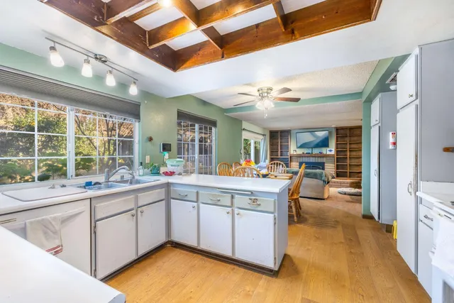 a large white kitchen with a large window
