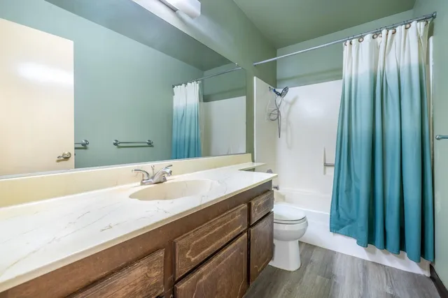 a bathroom with a granite countertop sink toilet and shower