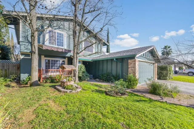 a view of a house with backyard and sitting area