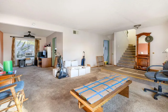 a living room with furniture a rug and wooden floor