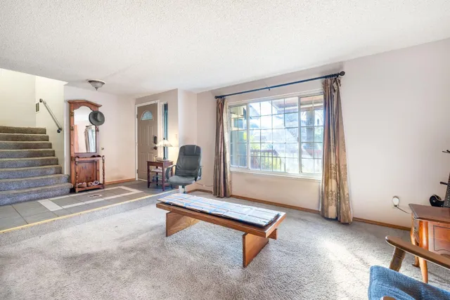 a living room with furniture a rug and a large window