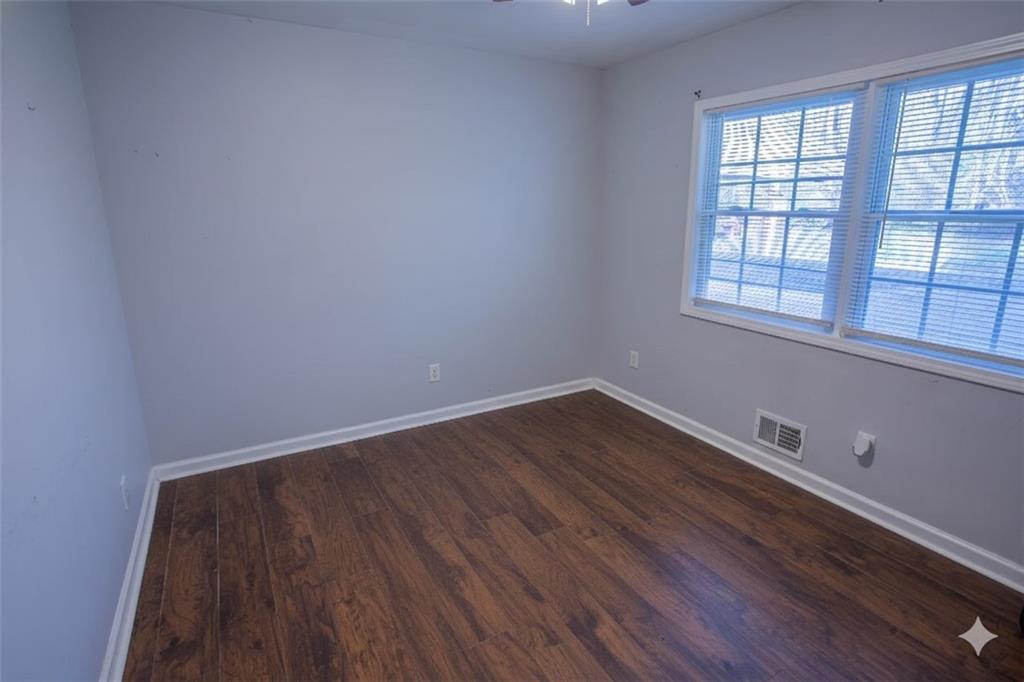 5215 Dixie Lake Road Union City, GA 30291 - Photo 10 of 12 an empty room with wooden floor and windows