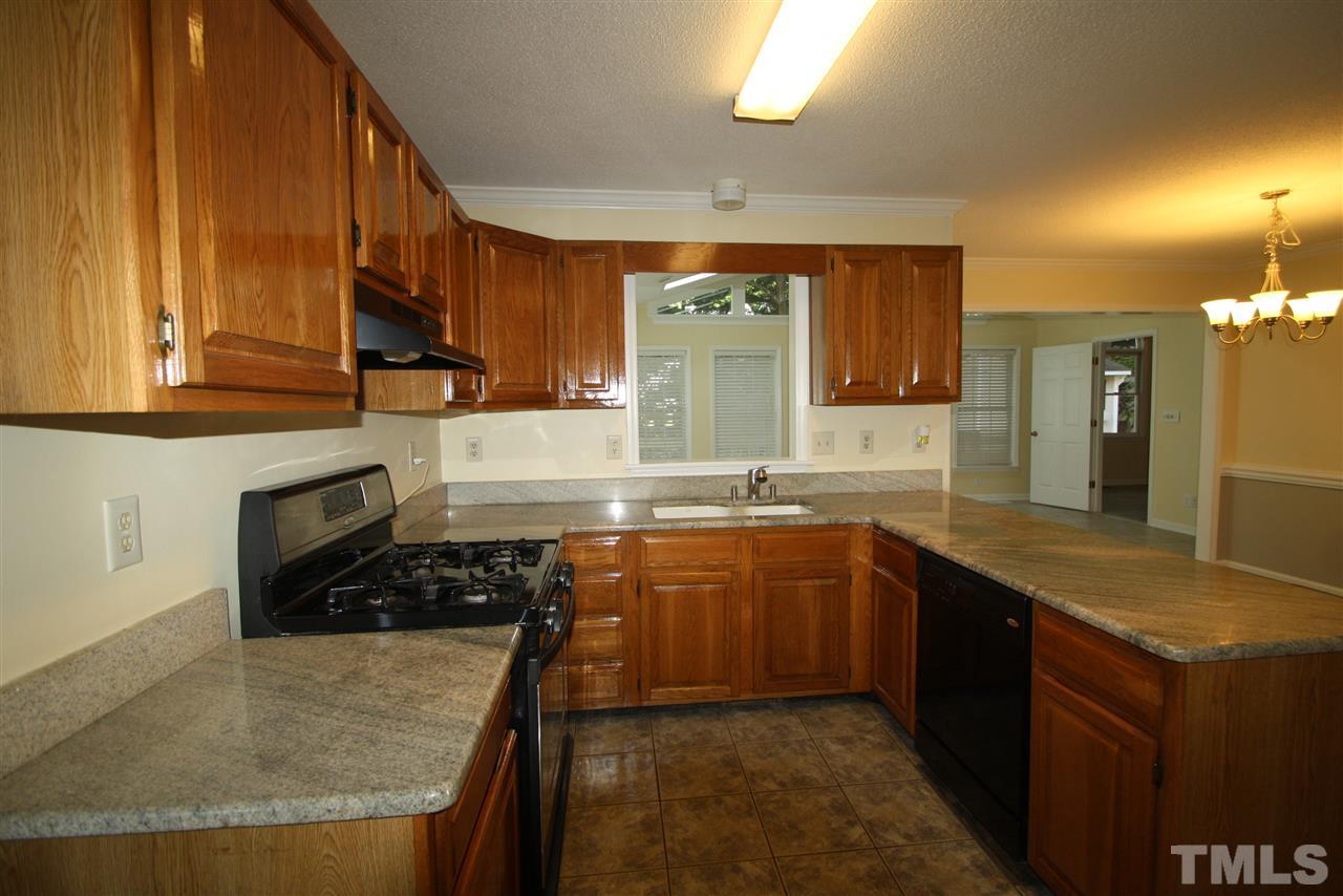 11924 Radner Way Raleigh, NC 27613 - Photo 5 of 25 a kitchen with stainless steel appliances granite countertop a sink stove and cabinets