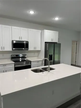 a kitchen with kitchen island granite countertop a sink and a stove