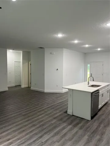 a view of kitchen with stainless steel appliances granite countertop a stove a sink and a refrigerator
