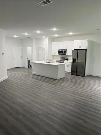 a view of a kitchen with a refrigerator a ceiling fan and wooden floor
