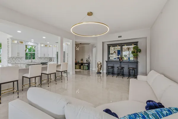 a living room with furniture and a dining table with wooden floor