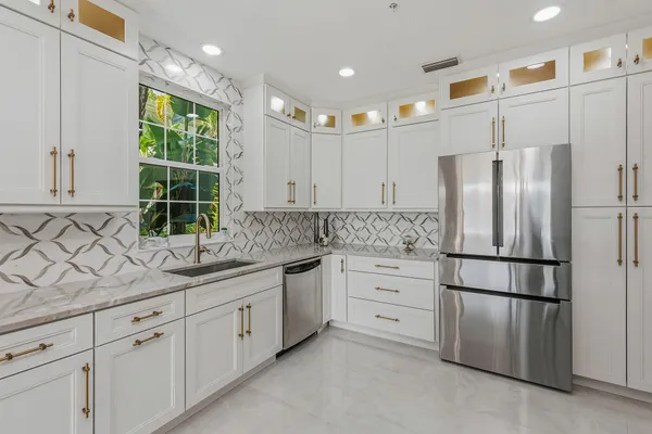 a kitchen with stainless steel appliances granite countertop a refrigerator sink and cabinets
