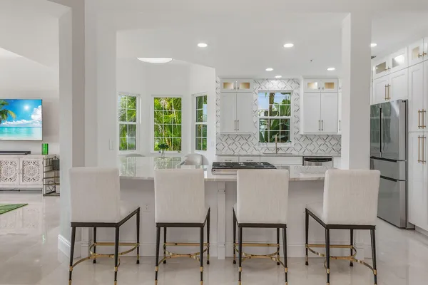 a kitchen with a table chairs refrigerator and cabinets
