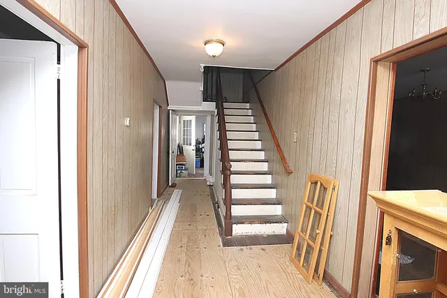 a view of a hallway with wooden floor and staircase