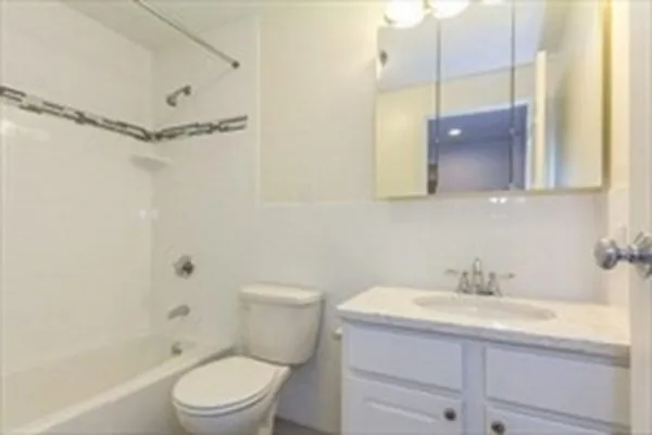 a bathroom with a granite countertop sink a toilet and shower