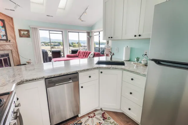 a kitchen with granite countertop white cabinets and white appliances