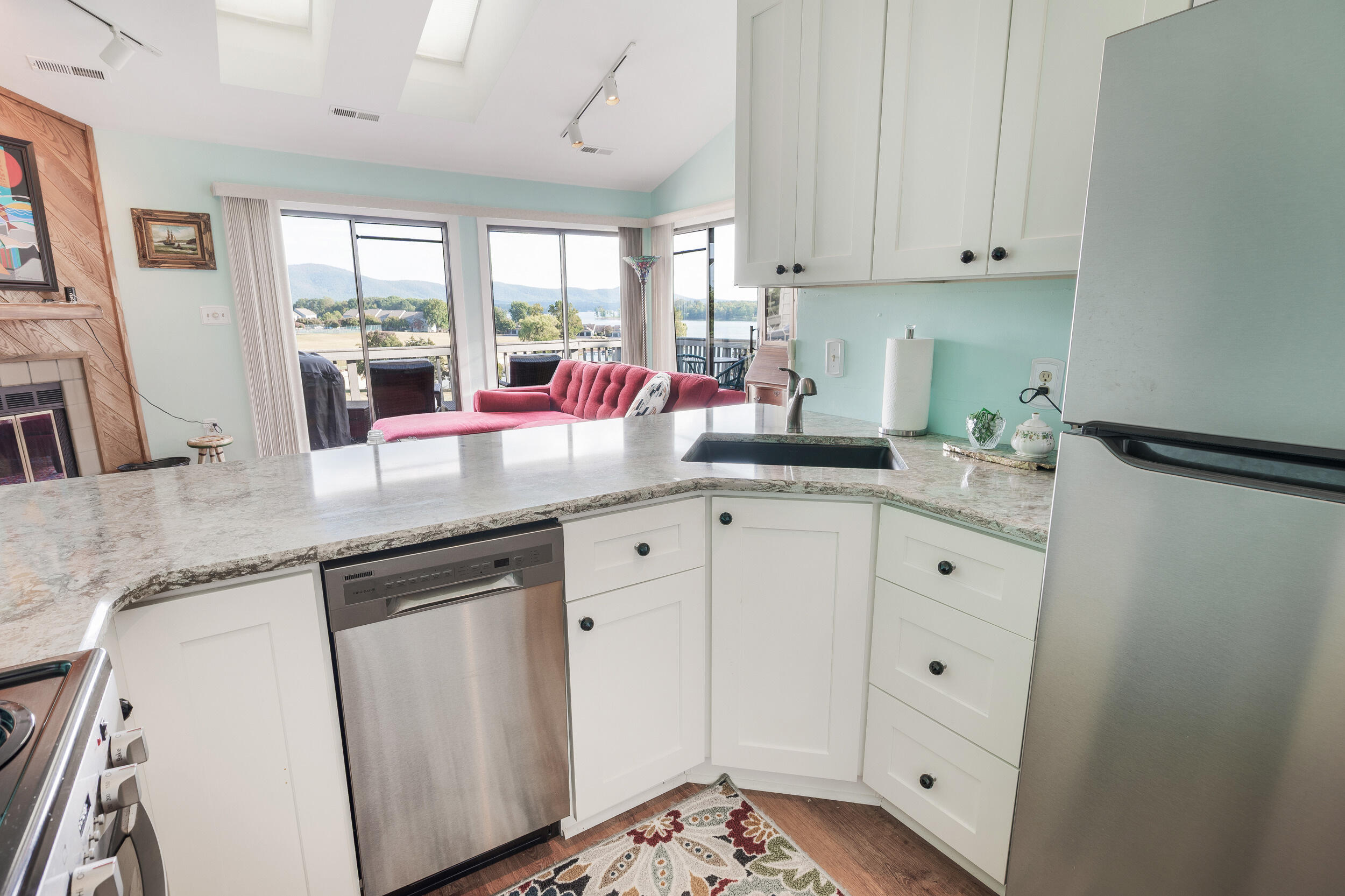 150 Sailor's Cove Drive, Unit 1218 Moneta, VA 24121 - Photo 6 of 56 a kitchen with granite countertop white cabinets and white appliances