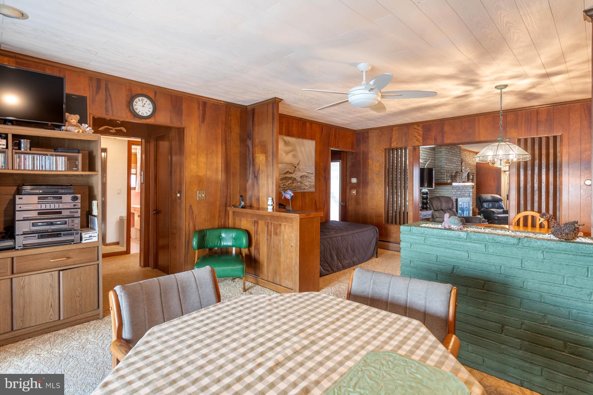 31266 River Road Millsboro, DE 19966 - Photo 24 of 47 a bedroom with a bed a chandelier and a flat tv screen