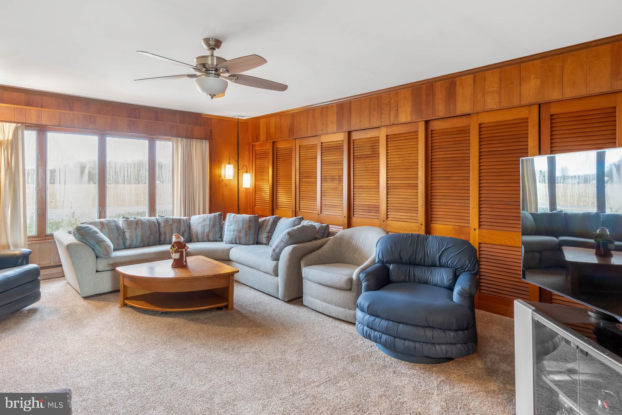 31266 River Road Millsboro, DE 19966 - Photo 7 of 47 a living room with furniture a ceiling fan and a large window