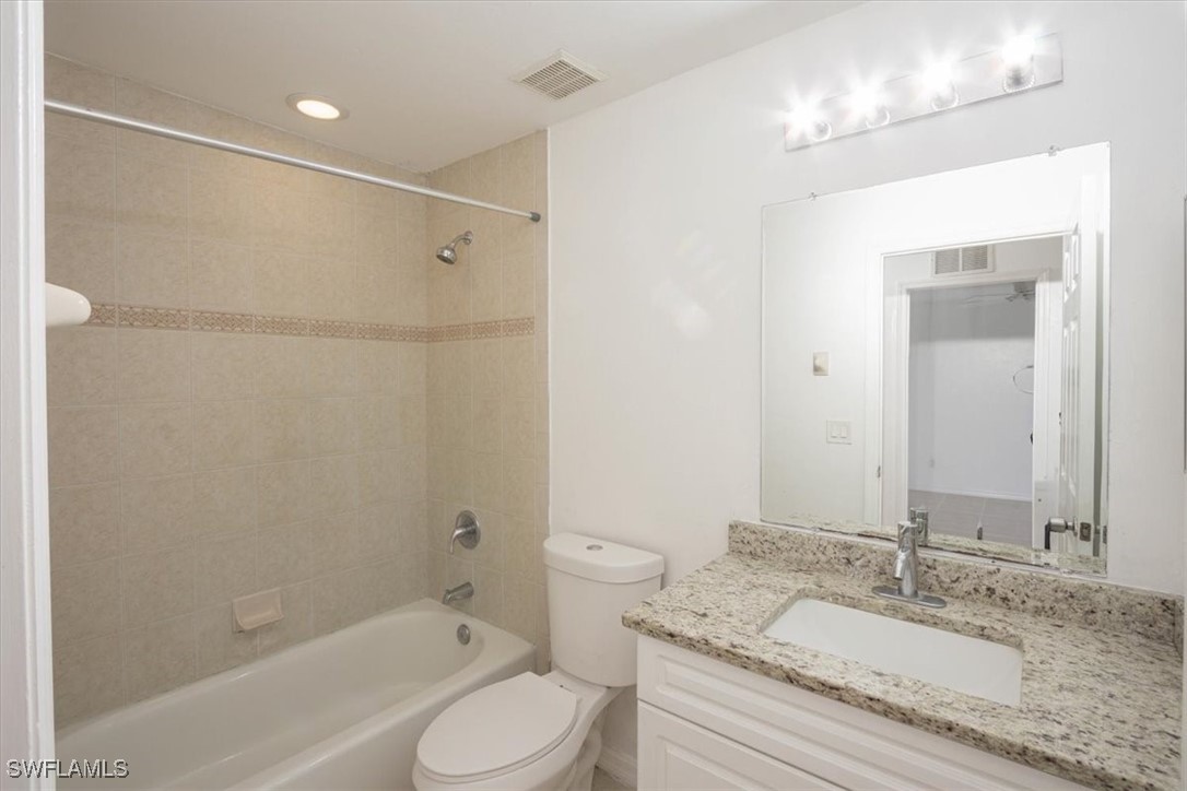 3980 Sunset Road Lehigh Acres, FL 33971 - Photo 16 of 23 a bathroom with a granite countertop sink toilet and shower