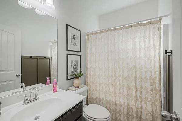 a bathroom with a sink vanity mirror and toilet