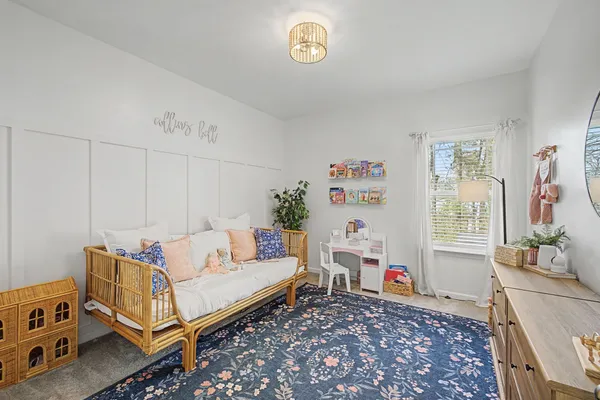 a living room with furniture and a baby crib