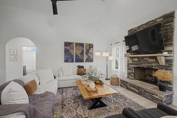 a living room with furniture a flat screen tv and a fireplace