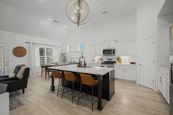 a kitchen with a dining table chairs and a refrigerator
