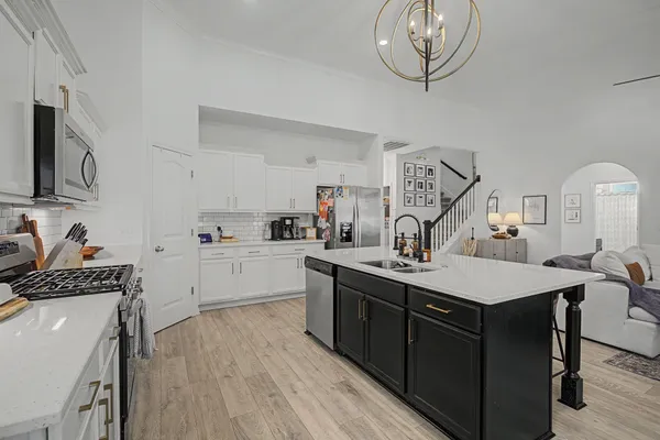 a kitchen with a sink dishwasher a stove and a refrigerator with wooden floor