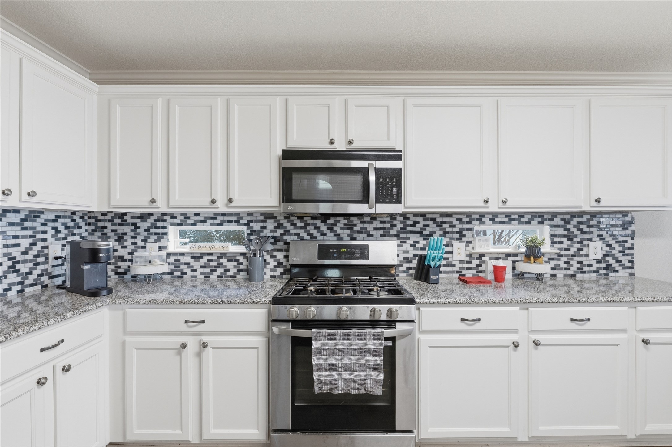258 Hogan Kyle, TX 78640 - Photo 13 of 40 a kitchen with white cabinets and appliances